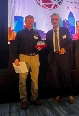 Todd Depauw is presented with the award for "Future of Simulation Technology" by Manfred Zehn, at the 2023 NAFEMS World Congress.