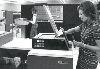 Woman feeds punch cards into machine